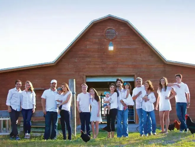 A group of people standing in front of a barn.